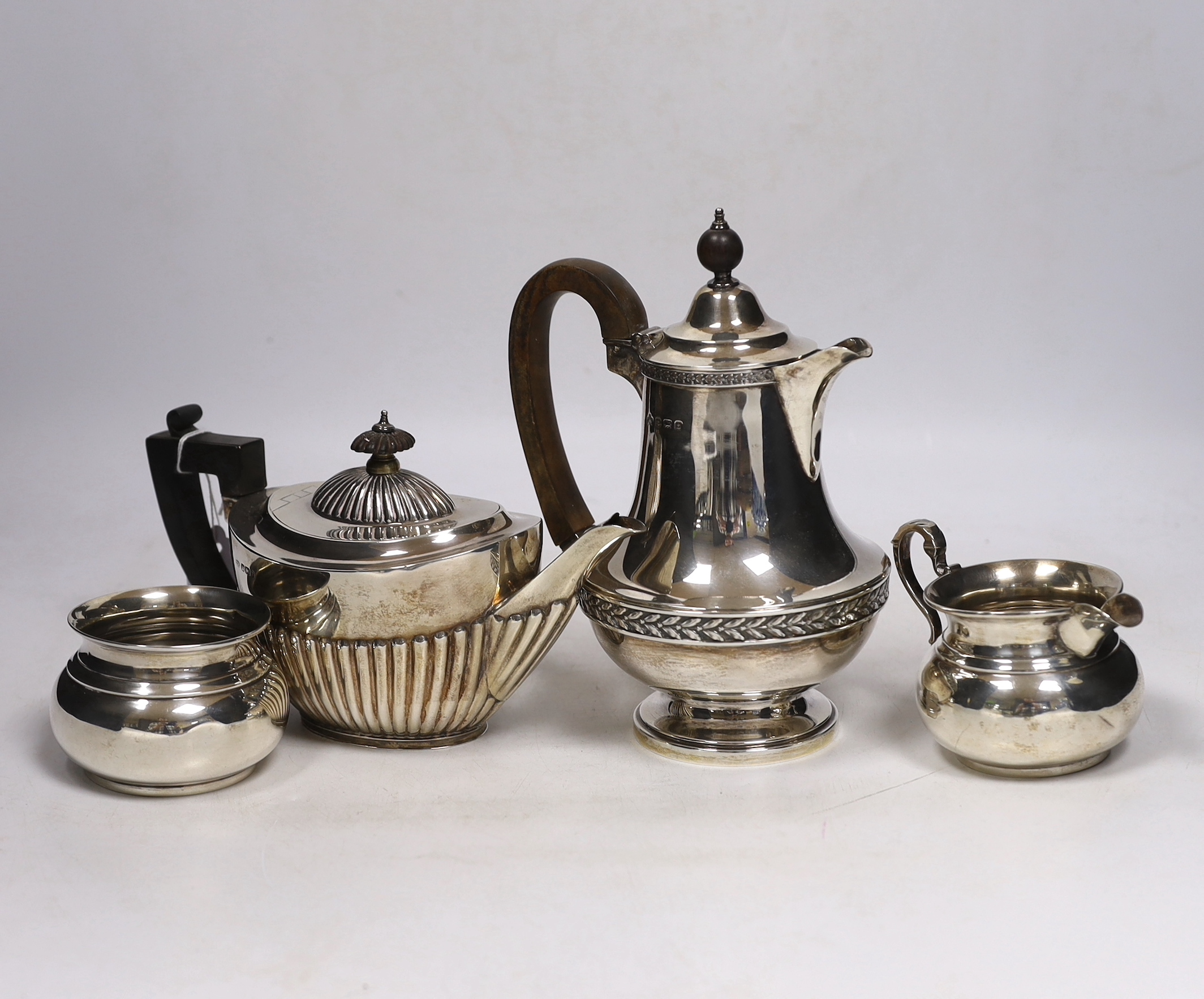 A late Victorian demi fluted silver oval teapot, John Round, Sheffield, 1897, a later silver hot water pot by Elkington & Co and a silver cream jug and sugar bowl, gross weight 28.5oz.